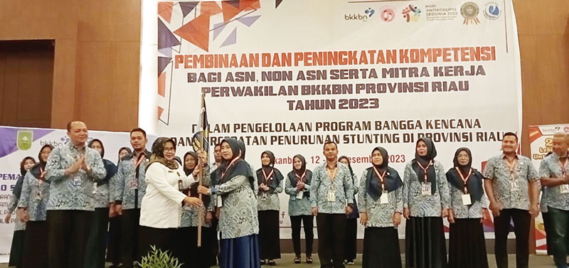 Ketua Umum Ikatan Penyuluh Keluarga Berencana Indonesia (IPeKB Indonesia) Provinsi Riau Sri Rejeki SIKom (kanan) menerima bendera organisasi atau pataka yang diserahkan Kepala Perwakilan BKKBN Riau Dra Mardalena Wati Yulia MSi (tengah) dan didampingi  Ket