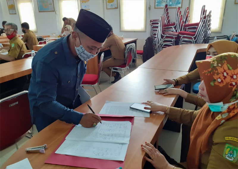 Wakil Ketua DPRD Rohil Basiran Nur Efendi SE saat mengisi absen menghadiri kegiatan di Bappeda Rohil, Senin (15/6). (ZULFADHLI/RIAUPOS.CO)
