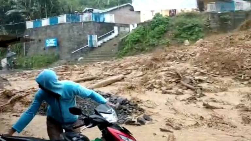Seorang pengendara sepeda motor terlihat kesulitan saat menembus material lumpur yang tumpah di jalan saat banjir bandang melanda Parapat, Kabupaten Simalungung, Sumatra Utara. (JPNN)