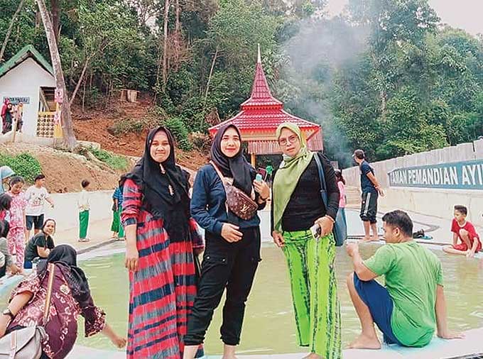 Pengunjung objek wisata pemandian Air Panas Desa Sungai Pinang, Kecamatan Hulu Kuantan,  berpose di areal kolam pemandian, Jumat (5/3/2021).
