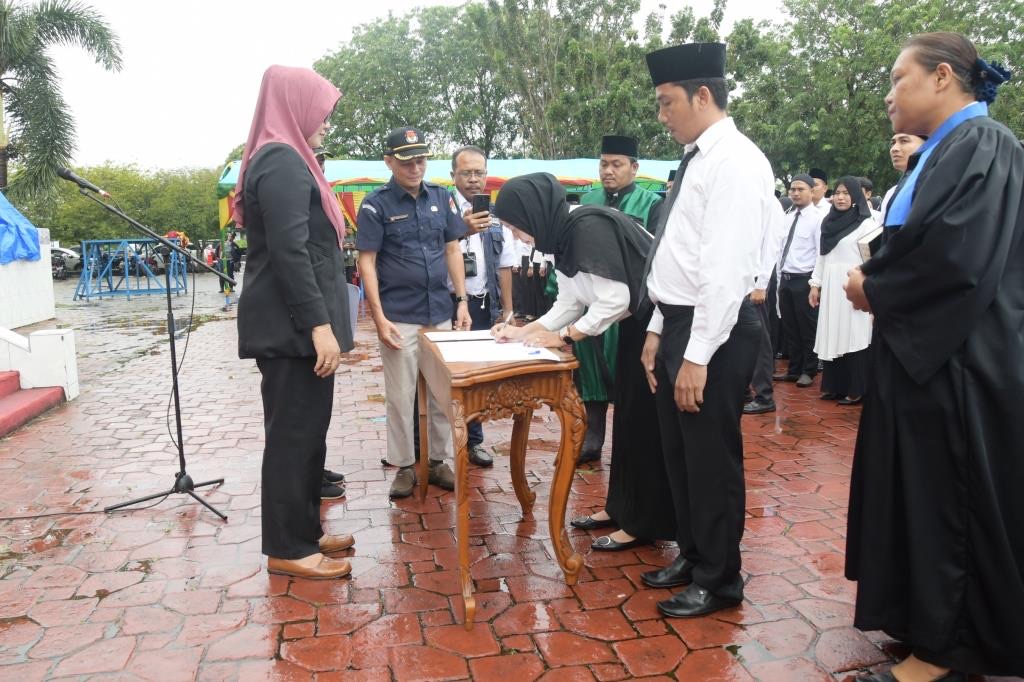 Ketua KPU Bengkalis disamsikan Wakil Bupati Bengkalis, H Bagus Santoso menyetahkan SK petugas PPS yang baru dilantik, di Lapangan Tugu Bengkalis, Selasa (24/1/2023).