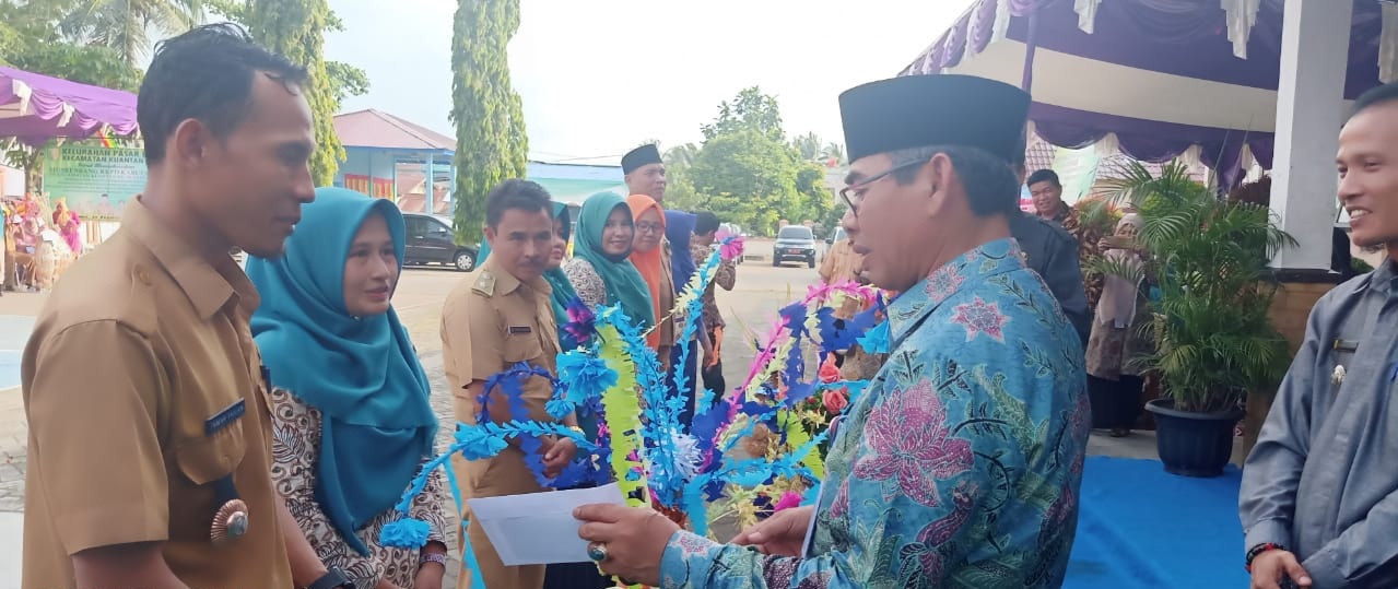 Bupati Kuansing, Drs H Mursini MSi, memberikan apresiasi kepada tim PKK yang telah menampilkan Sasampek saat pawai Musrenbang di Kecamatan Kuantan Hilir, Kamis (13/2/2020). (MARDIAS CHAN/RIAUPOS.CO)