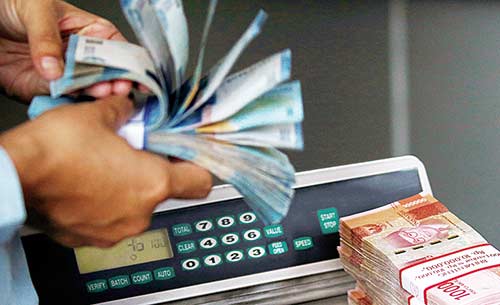 HITUNG UANG: Pegawai bank menghitung pecahan rupiah, belum lama ini. Rupiah terus melemah, bahkan mencapai Rp14.815 per dolar Amerika Serikat. (DIMAS PRABOWO/JPG)
