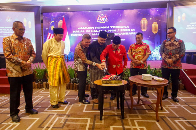 Wakil Konsulat Malaysia Pekanbaru Awaluddin Mohd Nasir (tengah) bersama Asisten III Setdaprov Riau Joni Irwan (tiga kanan) disaksikan sejumlah undangan memotong kue saat acara halalbihalal Konsulat Malaysia  di  Pekanbaru, Kamis (18/5/2023).