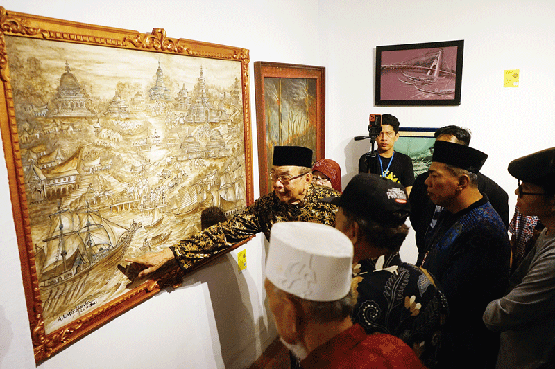 Seniman dan Budayawan Riau OK Nizami Jamil disaksikan Ketua Komisi I DPRD Riau Edy Mohd Yatim, Ketua KPU Riau Ilham Muhammad Yasir, dan Ketua GHN Furqon Elwe  menunjuk lukisan Muara Takus Kuno karya Latief Hasyim pada malam pembukaan Pameran Seni Rupa Mas