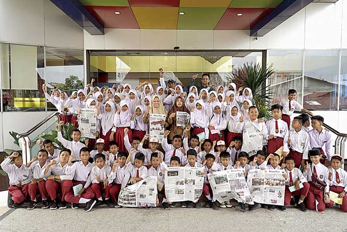 Murid SDN 24 Tanah Merah Siak Hulu foto bersama dengan Redaktur Pelaksana Pendapatan Riau Pos Syahrul Mukhlis saat mengunjungi redaksi Riau Pos, Selasa (21/2/2023).