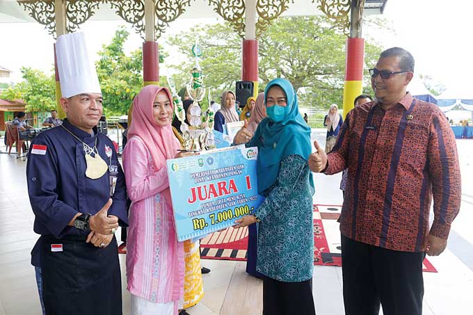 Ketua TP-PKK Siak Rasidah Alfedri menyerahkan piala kepada juara I lomba cipta menu B2SA dari Kecamatan Sungai Mandau di pentas Siak Bermadah pada Selasa (13/12/2022).