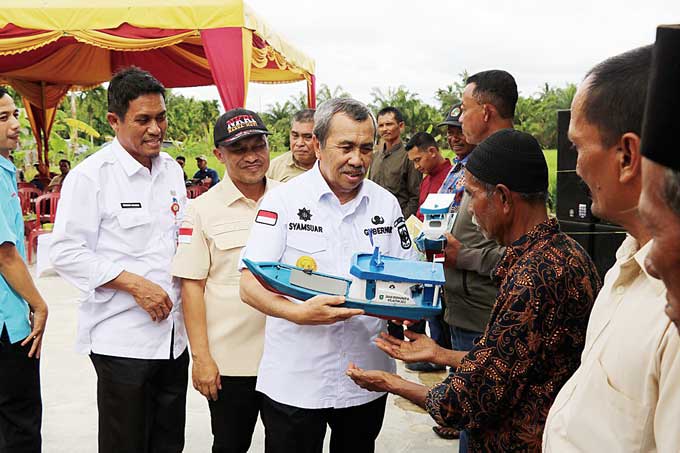 Gubernur Riau Drs H Syamsuar saat menyerahkan bantuan kapal secara simbolis kepada nelayan di Kabupaten Bengkalis, baru-baru ini.