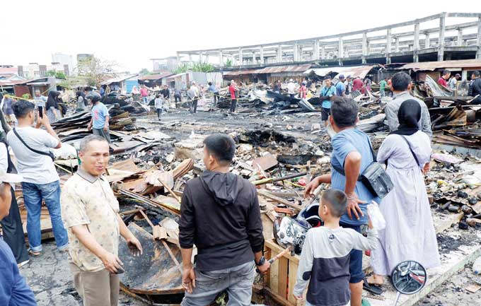 Para pedagang mulai mencari barang yang masih bernilai ekonomis di puing-puing kios yang terbakar di Pasar Cik Puan, Jalan Tuanku Tambusai, Pekanbaru, Senin (20/2/2023).