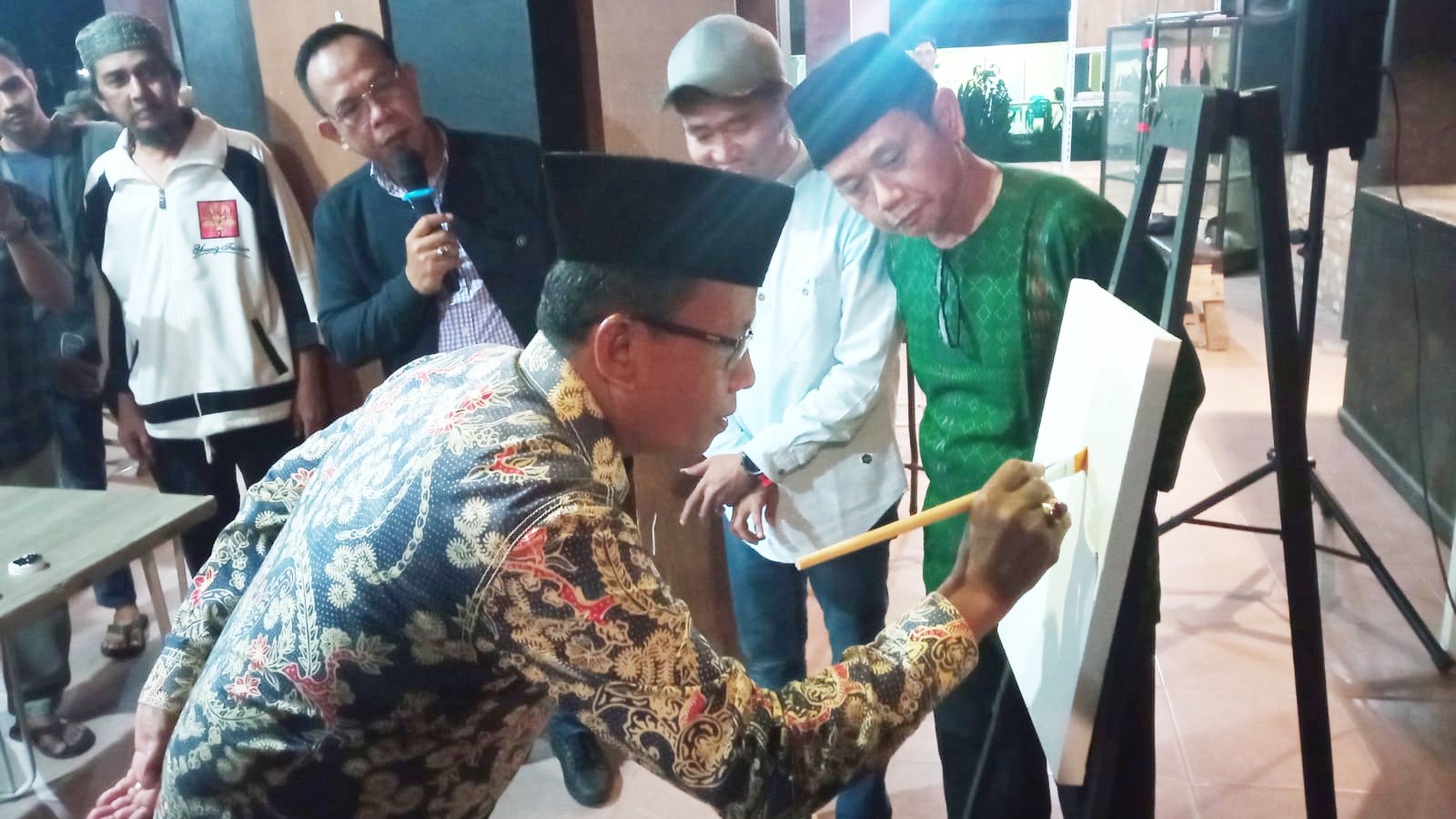 Disaksikan Ketua Galeri Hang Nadim, Furqon LW (baju hijau), Ketua LPTQ Pekanbaru Dr H Idrus melukis kaligrafi sebagai tanda pembukaan Pameran Kaligrafi Kontenporer Riau dengan tema