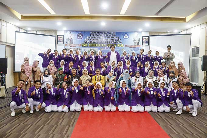 Ketua Yayasan Bintang Insani Nusantara Defi Endri MM MPd (jas kuning), Kepala SMK Kesehatan Genus Riau Rika Gusvita Kadar SST MKes (duduk tujuh kanan) foto bersama majelis guru, tamu undangan dan para siswa yang akan melaksanakan praktik kerja industri sa