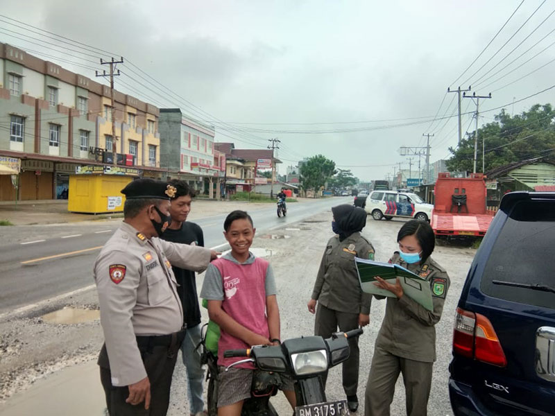 Tim Yustisi Covid-19 mendata dan memberikan sanksi terhadap warga saat terjaring akibat tidak mentaati protokol kesehatan, Kamis (1/10/2020). (RAJA KASMEDI/RIAUPOS.CO)