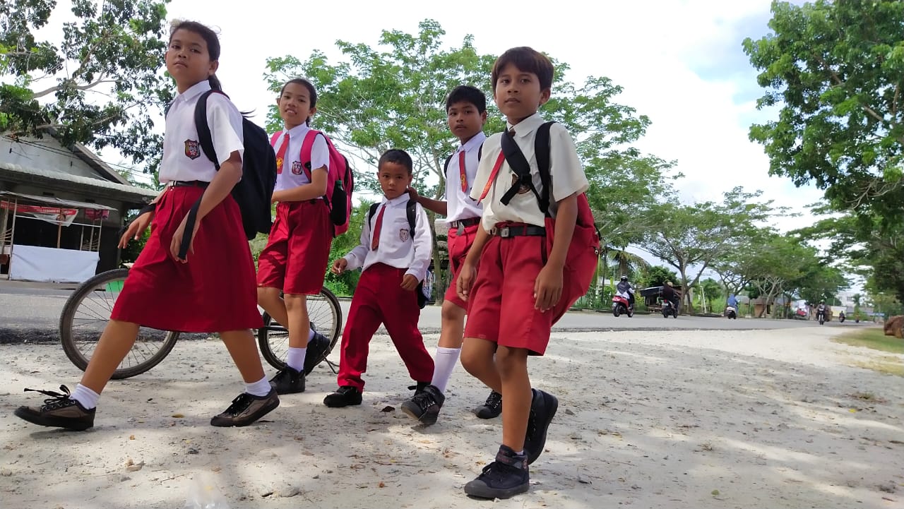 Beberapa orang murid SD berpakaian lengkap pulang sekolah jauh sebelum pandemi Covid-19, Jalan Dorak, Kecamatan Tebintinggi.(WIRA/RIAUPOS.CO)