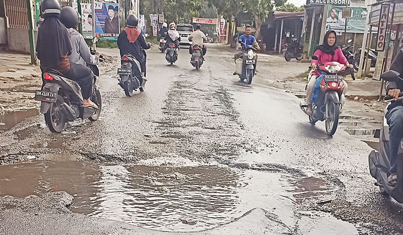 Jalan Kartama, Kecamatan Marpoyan Damai Pekanbaru, persisnya di Simpang Jalan Pahlawan Kerja mengalami rusak parah, Senin (18/12/2023). Sampai saat ini belum ada tanda-tanda akan segera diperbaiki.