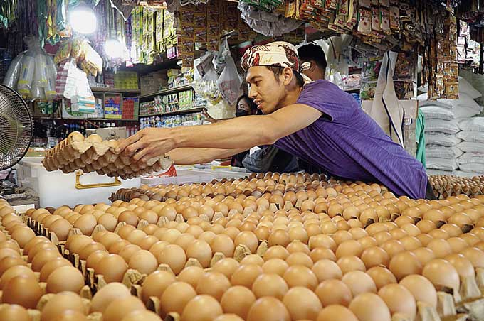Pedagang telur ayam menata telur-telur yang akan dijual di kios Pasar Pagi Arengka, Kota Pekanbaru, baru-baru ini.
