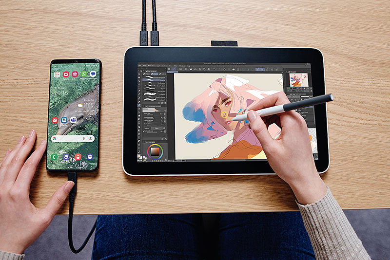 Seorang pelukis sedang menggunakan Pen display Wacom One 12 untuk menggambar wajah.