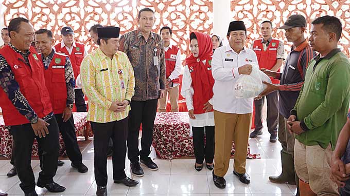 Bupati Rohul H Sukiman bersama Ketua PMI Rohul Hj Peni Herawati Sukiman menyerahkan secara simbolis bantuan paket sembako kepada ratusan petugas pertamanan dan kebersihan serta warga kurang mampu di Pendopo Rumah Dinas Bupati Rohul, Kamis (13/4/2023).