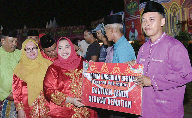 Bupati Bengkalis Kasmarni menyerahkan bantuan kepada masyarakat, usai membuka MTQ V Tingkat Kecamatan Talang Muandau, di halaman Kantor Camat Talang Muandau, Selasa (8/8/2023) malam.