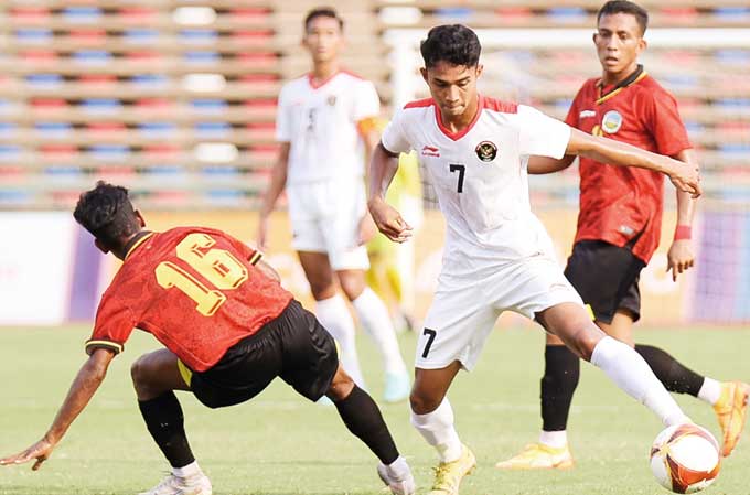 Gelandang Indonesia Marselino Ferdinan (kanan) melewati pemain Timor Leste di Olympic Stadium, Phnom Penh, Ahad (7/5/2023).