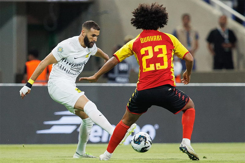 Karim Benzema (kirim) menggocek bola dalam laga debutnya bersama Al Ittihad di King Fad Stadium, Jumat (28/7).