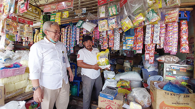 Salah seorang pedagang sembako di Pasar Lima Puluh, Marino didampingi Pemimpin Wilayah Perum Bulog Kanwil Riau dan Kepri Basirun, menunjukkan stok beras medium 5 Kg yang menipis akibat tingginya permintaan, Selasa (27/9/2022).