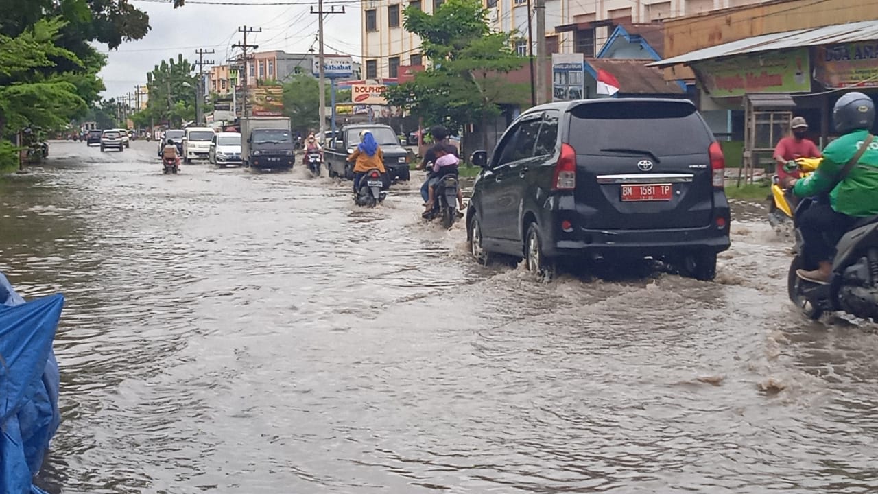 Kendaraan roda empat melintaso Genangan air di Jalan Hang Tuah Ujung, Rabu (22/9/2021).