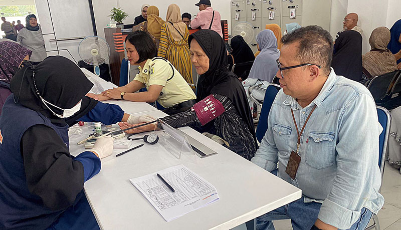 Regional Operation Head BRI Pekanbaru Sudirman Mohammad Selah (kanan) bersama para nasabah BRI saat mengecek kesehatan gratis yang gelar sempena HUT ke-128 BRI, Rabu (1/11/2023).