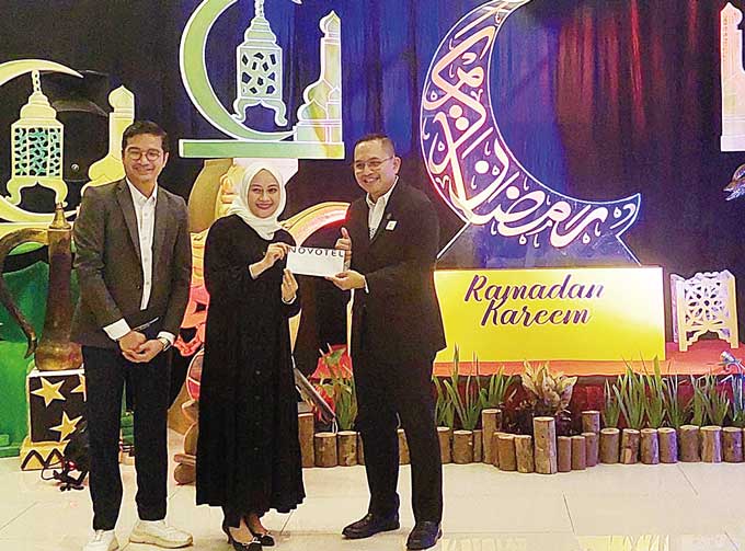 General Manager Novotel Pekanbaru, Sentot Lasiyanto menyerahkan hadiah berupa voucher kepada salah satu tamu undangan di sela buka puasa bersama yang digelar di Loby Novotel Pekanbaru, Kamis (30/3/2023).