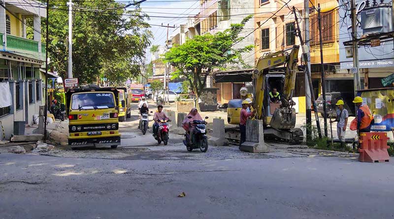Beberapa kendaraan truk dan sepeda motor terlihat melewati Jalan Tanjung Batu Kecamatan Lima Puluh, Pekanbaru, yang berdebu, Sabtu (7/1/2023).