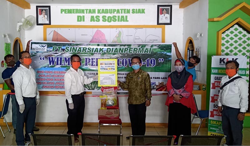 Sekretaris Dinas Sosial Kabupaten Siak menerima bantuan sembako dari Estate Manajer PT SSDP, Kamis (23/4/2020). Humas PT SSDP for Riau Pos