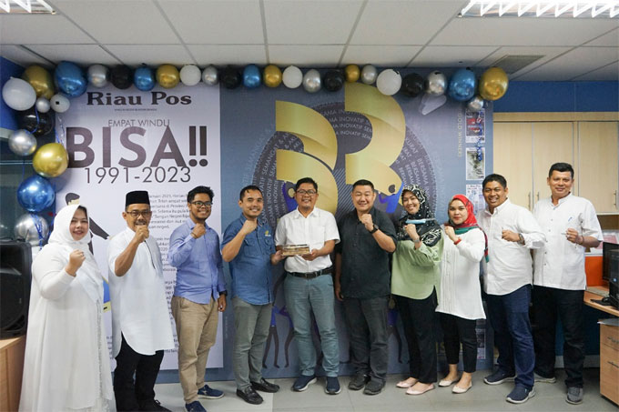 Direktur Utama Riau Pos Ahmad Dardiri (tengah) menerima kue tar dari  PT Capella Dinamik Nusantara Riau saat HHUT ke-32 Riau Pos yang dihadiri Promotion and Advertising Section Head Hariyanto Budhiman (empat kanan), Honda Customer Care Manager Toni Hadi W