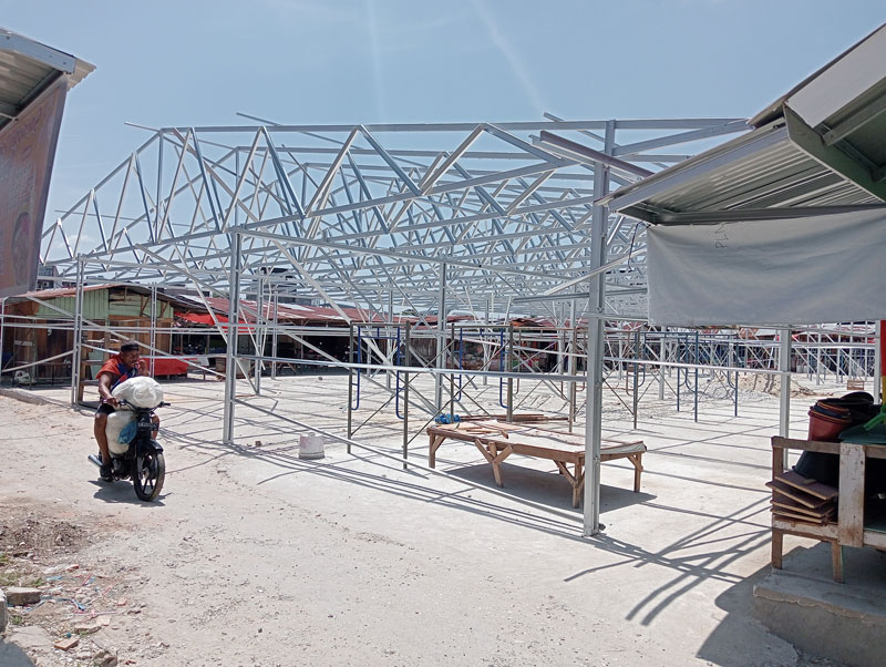 Warga melintas di dekat lokasi pembangunan los untuk pedagang kaki lima (PKL) di Pasar Cik Puan, Jalan Tuanku Tambusai, Selasa (25/7/2023).