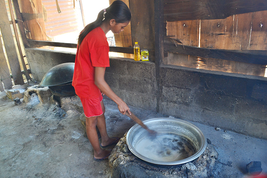 Dai Ovian Uy ketika mengaduk cairan getah lontar dalam proses pembuatan gula curah atau gula semut, gula khas Sabu Raijua. (HARY B KORIUN/RIAUPOS.CO)