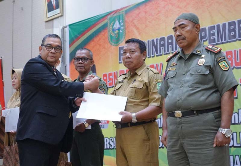 Plt Gubernur Riau Edy Natar Nasution menyerahkan SK pensiun kepada salah seorang ASN di lingkungan Pemerintah Provinsi Riau, Senin (20/11/2023).