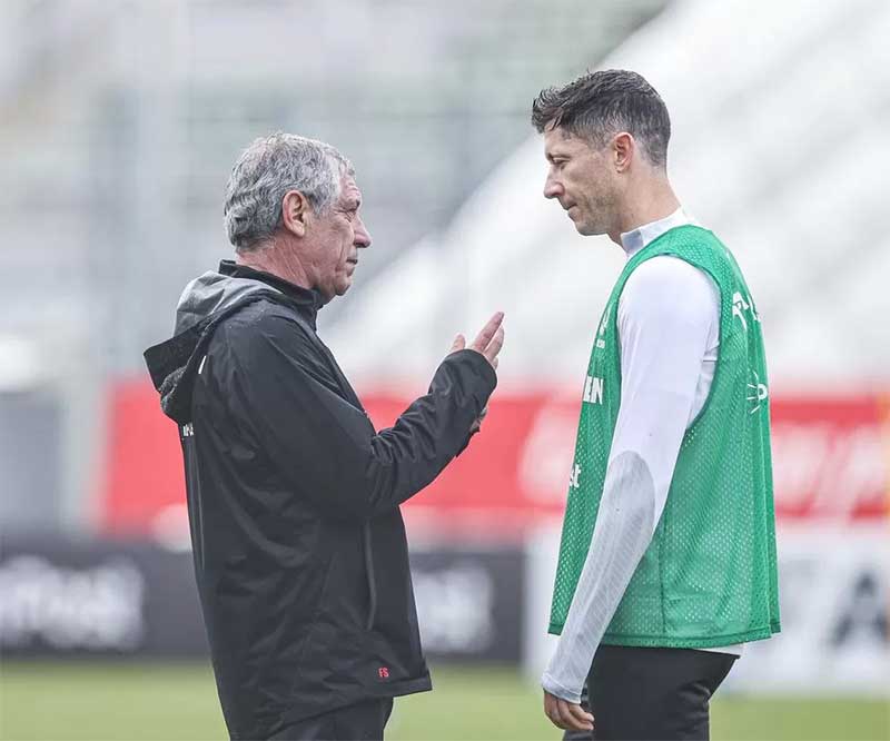 Pelatih Fernando Santos berbicara dengan kapten sekaligus bomber Polandia Robert Lewandowski dalam sesi latihan pekan lalu.