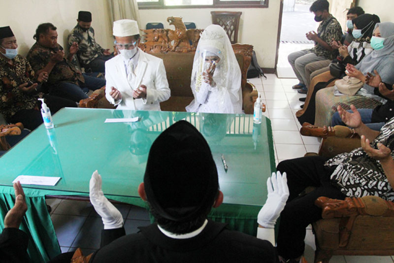 Sepasang pengantin melangsungkan pernikahan di KUA.