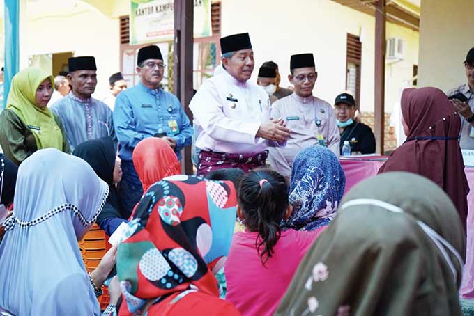 Bupati Alfedri  berbincang dengan warga memastikan semua mendapatkan pelayanan dengan baik pada Bujang Kampung di Dosan, Kecamatan Pusako, Jumat (15/7/2022).
