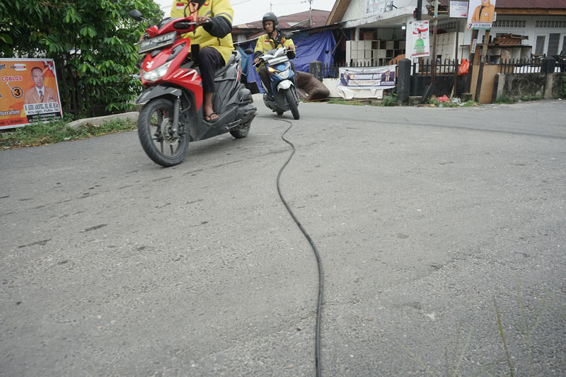 Kabel telekomunikasi melintang di Jalan Durian  dekat simpang Jalan Pepaya ujung,  Senin (11/9/2023). Kondisi ini bisa membahayakan pengendara sepeda motor yang melintas.