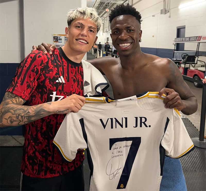 Vinicius Junior (kanan) memberikan jersey nomor punggung 7 miliknya kepada winger Manchester United Alejandro Garnacho.