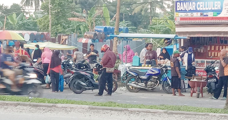 Pedagang pasar kaget Perumahan Sidomulyo, Pekanbaru yang ditutup, menggelar dagangan di tepi  Arengka Atas (Jl Soekarno-Hatta) sebelah lokasi perumahan tersebut, Jumat (10/4/2020).(FURQON LW/RIAUPOS.COM)