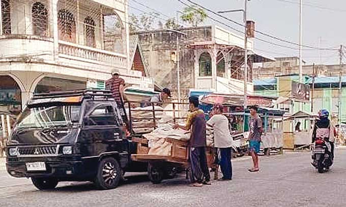 Para buruh melakukan aktivitas bongkar muat barang di Jalan Hasanuddin, Kota Bengkalis, Senin (1/5/2023).