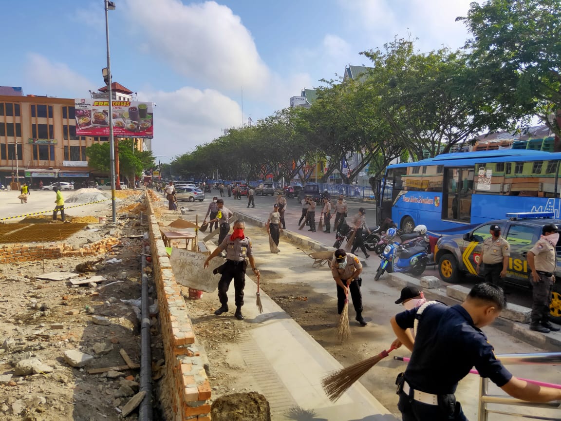 Personil Polresta Pekanbaru laksanakan Gotong Royong di depan Pasar Sukaramai, Jalan Sudirman, Sabtu (14/03/2020). (BAYU SAPUTRA/RIAUPOS.CO)