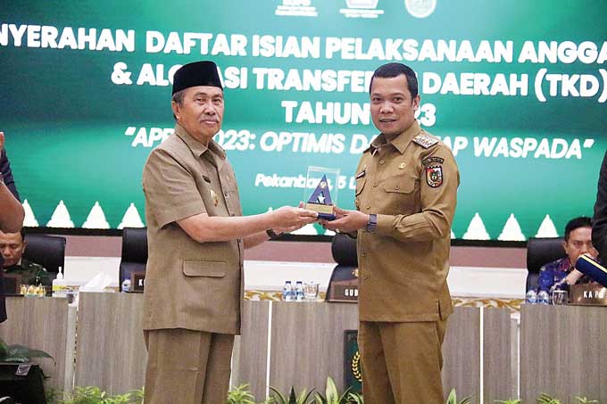 Pj Wako Pekanbaru Muflihun menerima penghargaan dari Menkeu yang diserahkan Gubernur Riau Syamsuar atas opini Wajar Tanpa Pengecualian (WTP) Laporan Keuangan Pemerintah Daerah di Balai Serindit Aula Gubernuran, Senin (5/12/2022).
