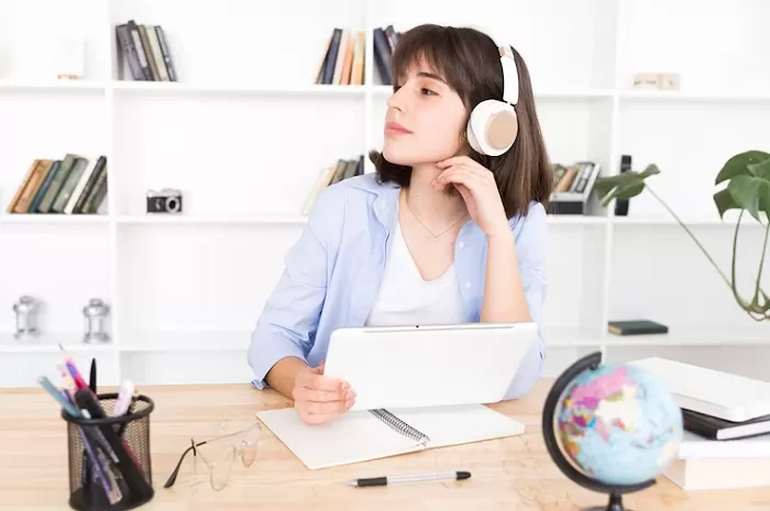 Ilustrasi. Seorang mahasiswi yang sedang belajar dengan mendengarkan musik.