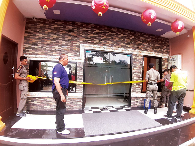 Tim gabungan Pemkab Rohil melakukan penyegelan salah satu tempat hiburan karaoke di Bagansiapiapi dengan memasang kertas pengumuman tanda penyegelan serta garis di Bagansiapiapi, Kamis (5/3/2020). (ZULFADHLI/RIAUPOS.CO)