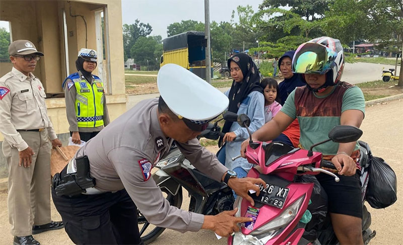 Anggota Satlantas Polres Kuansing memasang stiker imbauan tertib lalu lintas ke kendaraan di Telukkuantan, Rabu (6/9/2023).