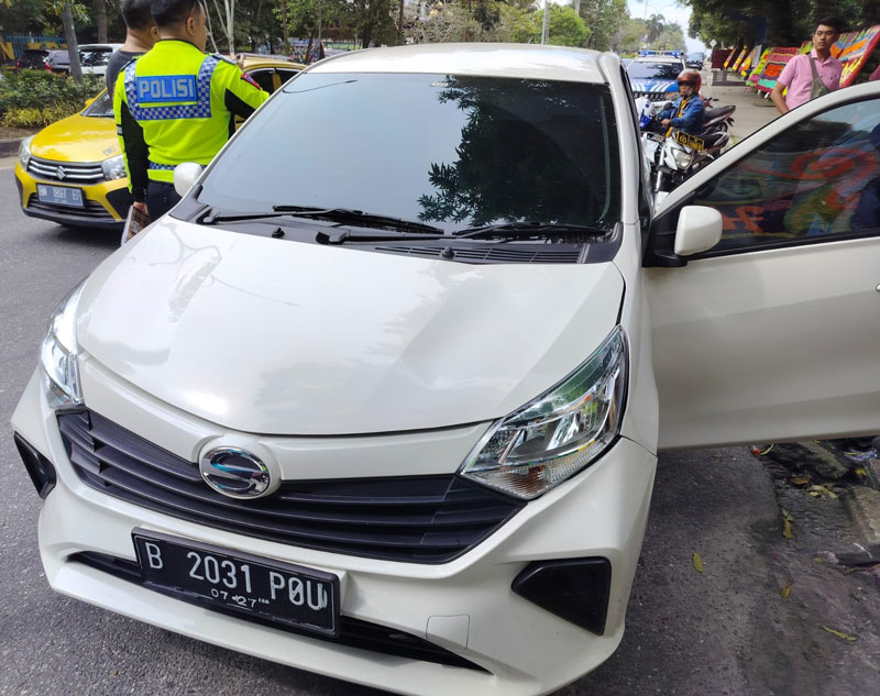 Petugas Satlantas Polresta Pekanbaru memeriksa mobil yang dikendarai pria yang mengalami serangan jantung terhenti di tepi Jalan Diponegoro, Pekanbaru setelah menabrak median jalan, Ahad (10/12/2023).
