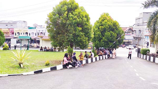 Warga duduk di sekitar halaman Pengadilan Negeri Rengat untuk melihat jalannya sidang sebelum dibubarkan oleh polisi, Kamis (8/10/2020).(kasmedi/riaupos.co)