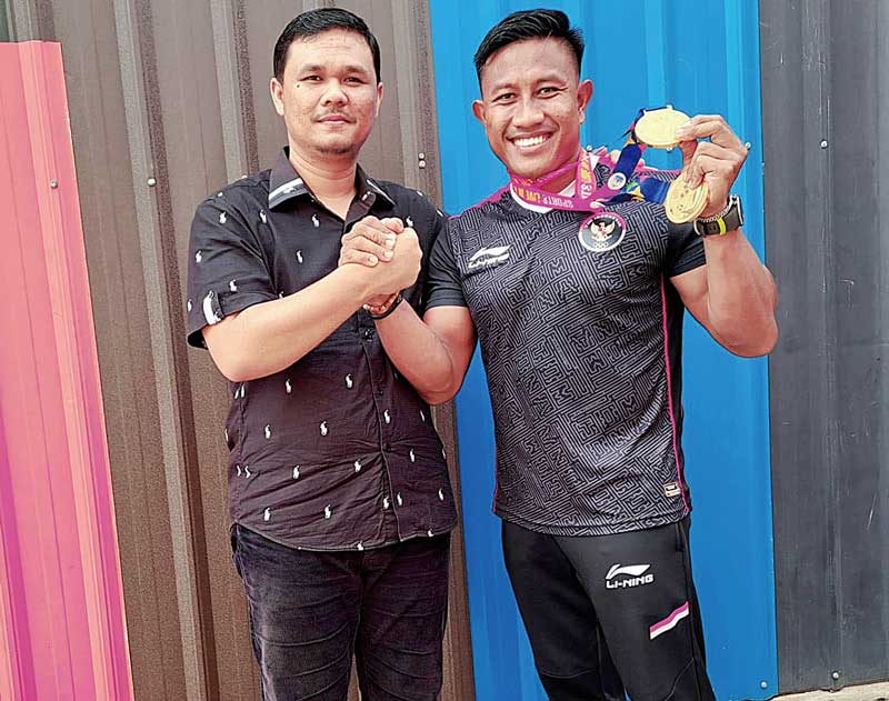 Atlet dayung peraih emas SEA Games 2023 Maizir Riyondra (kanan) salam komando dengan Ketua DPRD Kuantan Singingi Adam saat bertemu di Telukkuantan, Selasa (23/5/2023).
