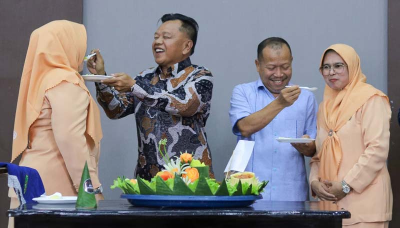 Plt Bupati Kepulauan Meranti H Asmar menyuapkan tumpeng kepada Ketua DWP Kepulauan Meranti Hj Fitria turut diikuti Sekda Bambang Suprianto dan istri, Ahad (10/12/2023).